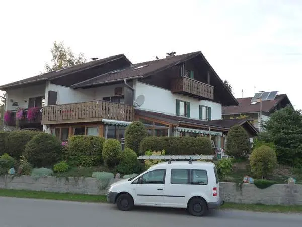 Wohnhaus mit verwitterten Holzbalkonen vor der Renovierung